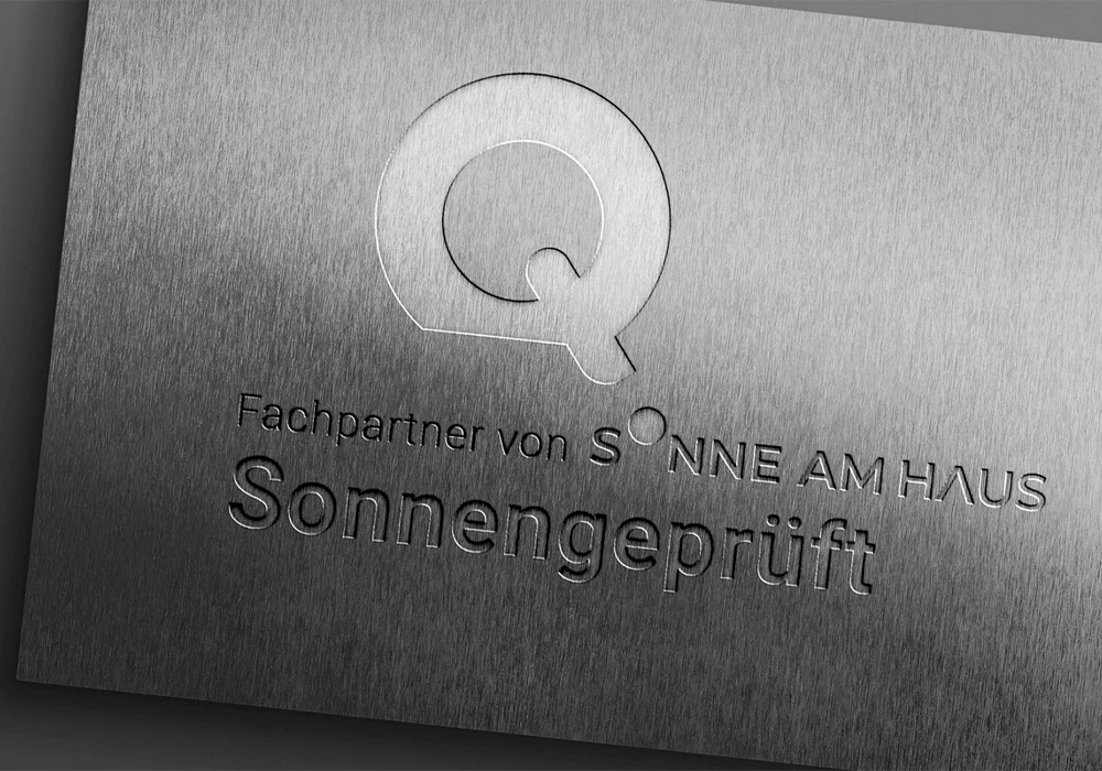 Metallische Plakette mit eingraviertem Logo und Schriftzug „Fachpartner von Sonne am Haus – Sonnengeprüft“