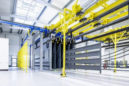 Fahrerloses Transportfahrzeug wird mit fertig beschichtetem Material beladen