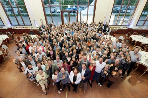 Große Gruppe an Menschen stehen zusammen für ein Foto