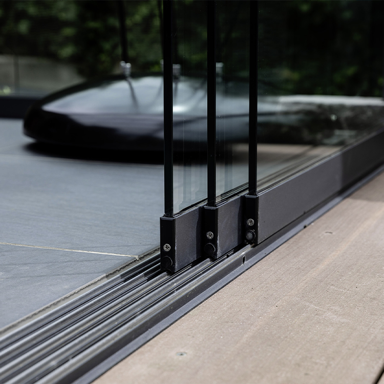 Detailansicht der bodenbündigen Schiebeschiene eines rahmenlosen Glasschiebersystems für Terrassenüberdachungen.