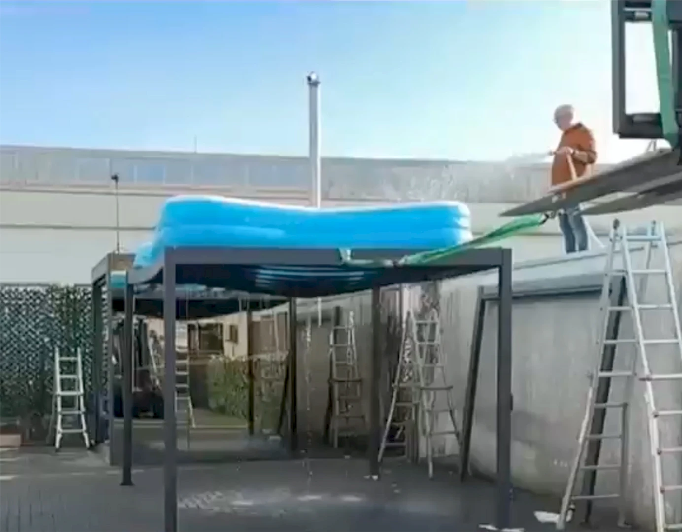 Qualitätstest einer Terrassenüberdachung – Wasser wird aus einem großen Becken auf das Dach geleitet, um die Stabilität und Dichtigkeit zu prüfen.